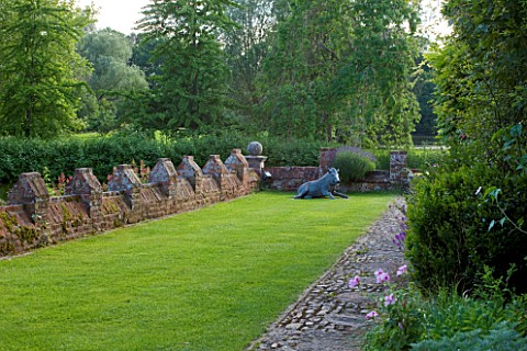 BIRTSMORTON_COURT_WORCESTERSHIRE_TERRACE_BESIDE_THE_HOUSE_WITH_LAWN_AND_SCULPTURE_OF_WILD_BOAR__SUMM
