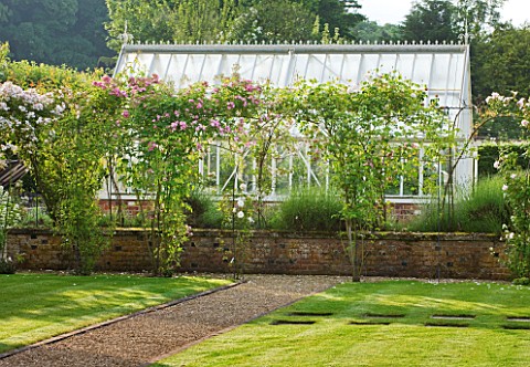 POULTON_HOUSE_GARDEN_WILTSHIRE_PATH_AND_LAWN_WITH_STEPPING_STONES_LEADING_TO_GREENHOUSEGLASSHOUSE_WI