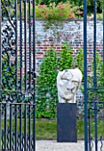 POULTON HOUSE GARDEN, WILTSHIRE: WROUGHT IRON GATES AND STONE SCULPTURE IN THE WALLED GARDEN - MARBLE SCULPTURE - HERACLITUS - BY EMILY YOUNG