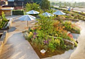 HORATIOS GARDEN  SALISBURY HOSPITAL  WILTSHIRE - DESIGNER CLEEVE WEST - VIEW FROM THE SPINAL UNIT DOWN ONTO THE GARDEN WITH LIMESTONE WALLS  CENTRANTHUS AND STIPA GIGANTEA