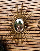 BEN DE LISI HOUSE AND GARDEN  LONDON: FRENCH SIXTIES STARBURST MIRROR ON WOODEN PANELLING