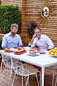 BEN DE LISI HOUSE AND GARDEN  LONDON: BEN DE LISI AND PARTNER GERARDO VIDAURRE EATING LUNCH AT A WHITE ALUMINIUM TABLE WITH PORCELAIN ENAMELLED STEEL TOP