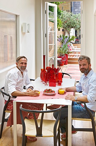 BEN_DE_LISI_HOUSE_AND_GARDEN__LONDON_VIEW_OUT_OF_KITCHEN_WITH_BEN_AND_GERARDO_AT_THE_TABLE_THROUGH_T