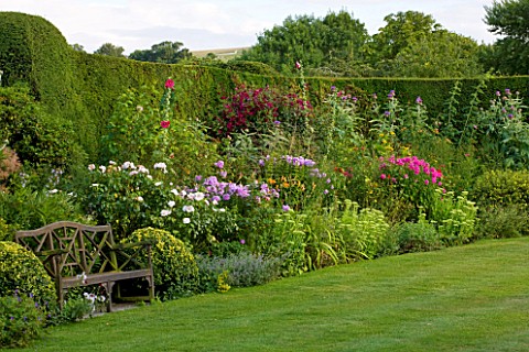 WOOLSTONE_MILL_HOUSE_OXFORDSHIRE_PERENNIAL_BORDER_BESIDE_CLIPPED_YEW_HEDGE_WITH_BENCH_A_PLACE_TO_SIT