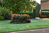 CHENIES MANOR, BUCKINGHAMSHIRE: LAWN AT FRONT OF MANOR HOUSE WITH BED OF DAHLIA DAVID HOWARD - COUNTRY GARDEN, FLOWERS, CLASSIC, GRASS