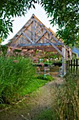MARCHANTS HARDY PLANTS, EAST SUSSEX: THE NURSERY - TIMBER SHELTER WITH LATH ROOF. WOOD