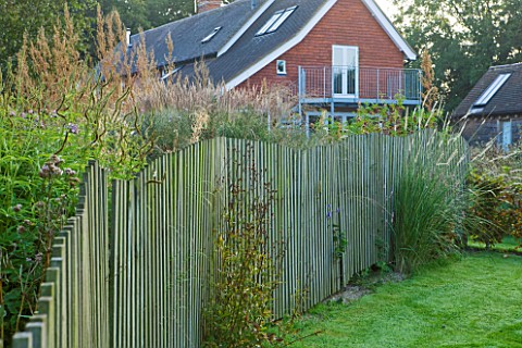 MARCHANTS_HARDY_PLANTS_EAST_SUSSEX_THE_HOUSE_WITH_LAWN_AND_WAVY_CHESTNUT_WOODEN_FENCE_FENCING_BOUNDA