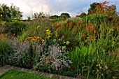 MARCHANTS HARDY PLANTS, EAST SUSSEX: HERBACEOUS BORDER WITH PERENNIALS AND GRASSES. HELENIUMS, COUNTRY, ENGLISH, GARDEN