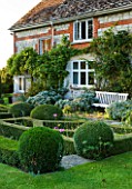 WOOLSTONE MILL HOUSE, OXFORDSHIRE: THE HOUSE WITH FORMAL PARTERRE, BOX BALLS AND BENCH.