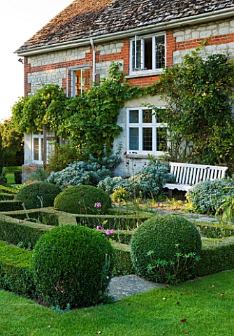 WOOLSTONE_MILL_HOUSE_OXFORDSHIRE_THE_HOUSE_WITH_FORMAL_PARTERRE_BOX_BALLS_AND_BENCH