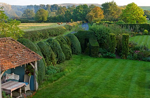 WOOLSTONE_MILL_HOUSE_OXFORDSHIRE_VIEW_ACROSS_LAWN_WITH_GARDEN_ROOM_AND_YEW_HEDGES__TAXUS_BACCATA