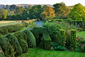 WOOLSTONE MILL HOUSE, OXFORDSHIRE: VIEW ACROSS THE GARDEN WITH YEW HEDGES - TAXUS BACCATA. HEDGE, STRUCTURE, CLIPPED, SHAPE, FORM