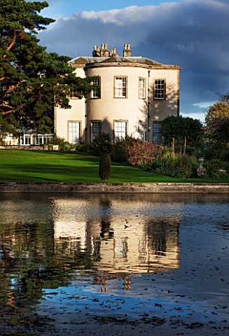 THORP_PERROW_ARBORETUM_YORKSHIRE__VIEW_ACROSS_THE_LAKE_TO_THE_HOUSE_IN_AUTUMN_CLASSIC_COUNTRY_GARDEN