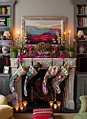 BUTTER WAKEFIELD HOUSE, LONDON. FAMILY ROOM AT CHRISTMAS: STOCKINGS HANG FROM THE MANTLEPIECE. ORCHIDS AND AN ARRANGEMENT OF DRIED HYDRANGEAS ADD FESTIVE DECORATION.