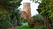EAST RUSTON OLD VICARAGE GARDEN, NORFOLK: VIEW OF CHURCH FROM WITHIN THE GARDEN
