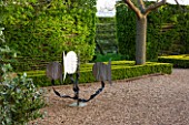 EAST RUSTON OLD VICARAGE GARDEN, NORFOLK: GRAVEL TERRACE, MODERN SCULPTURE, BOX HEDGING CUT INTO THIN STRIPS AROUND TREES - TOPIARY, CLIPPED, TRIMMED, BUXUS, TREES, SPRING