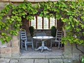 HADDON HALL, DERBYSHIRE: SUMMERHOUSE IN THE UPPER GARDEN WITH WOODEN TABLE AND CHAIRS