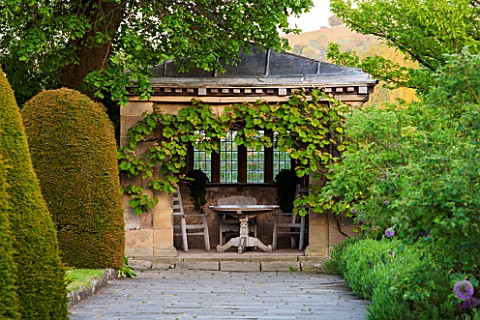 HADDON_HALL_DERBYSHIRE_SUMMERHOUSE_IN_THE_UPPER_GARDEN_WITH_WOODEN_TABLE_AND_CHAIRS