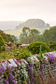 HADDON HALL, DERBYSHIRE: WALL WITH FLOWERS AND VIEW OF HILLS BEYOND