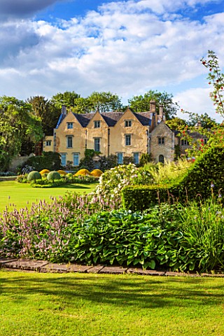 ABLINGTON_MANOR__GLOUCESTERSHIRE_VIEW_OF_THE_MANOR_HOUSE_WITH_LAWN_AND_BORDERS_OF_HOSTA__CLASSIC_COU