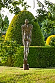GREAT FOSTERS. SURREY:  SOARING FIGURE - SCULPTURE IN STAINLESS STEEL BY RICK KIRBY BESIDE THE MOAT - WATER, ART, CLASSIC, FORMAL, COUNTRY GARDEN