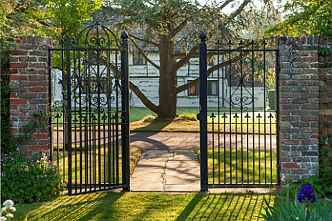 LITTLE_MYNTHURST_FARM_SURREY_METAL_GATE_FROM_WALLED_GARDEN_WITH_HOUSE_BEHIND_COUNTRY_GARDEN_ENGLISH_