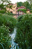 OLD NETLEY MILL, SHERE, SURREY: THE MILL SEEN FROM ACROSS THE LAKE. GARDEN, WATER, JUNE