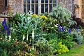 BROUGHTON CASTLE, OXFORDSHIRE: THE BATTLEMENT BORDER IN SUMMER WITH CARDOONS, DELPHINIUMS AND FOXGLOVES - FLOWERS, SUMMER, JUNE, HERBACEOUS BORDER, GARDEN