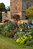 BROUGHTON CASTLE, OXFORDSHIRE: THE BATTLEMENT BORDER IN SUMMER WITH CARDOONS AND BLUE DELPHINIUMS - FLOWERS, SUMMER, JUNE, HERBACEOUS BORDER, GARDEN