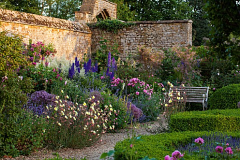 BROUGHTON_CASTLE_OXFORDSHIRE_BORDER_IN_THE_WALLED_GARDEN_WITH_ROSES_DELPHINIUMS_ALLIUMS_AND_OENOTHER