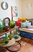 CIUTADELLA MENORCA, SPAIN: EVELYNE MANDEL HOUSE - FRONT ROOM, LIVING ROOM - VINTAGE GLASS JARS / CONTAINERS FROM MENORCA ON TABLE AND SIDEBOARD - SEAT WITH CUSHIONS