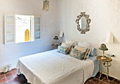 CIUTADELLA MENORCA, SPAIN: EVELYNE MANDEL HOUSE - MASTER BEDROOM - CLASSIC BEDROOM IN BLUE AND WHITE WITH CUSHIONS, ANTIQUE FRENCH MIRROR, TABLE LAMOS AND BEDSIDE TABLES