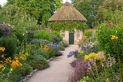 WEST_DEAN_GARDENS_WEST_SUSSEX_LATE_SUMMER_BORDERS_PLANTED_WIN_YELLOW_AND_BLUE__PATH_TO_SUNDIAL__HERB