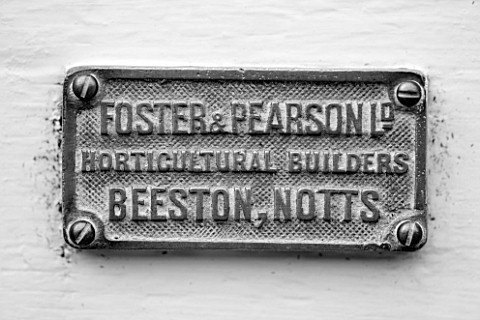 WEST_DEAN_GARDENS_WEST_SUSSEX_BLACK_AND_WHITE_IMAGE_OF_MAKERS_NAME_PLATE_ON_THE_DOOR_OF_A_GLASSHOUSE
