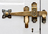 WEST DEAN GARDENS, WEST SUSSEX: BRASS DOOR HANDLE ON THE DOOR OF A GLASSHOUSE / GREENHOUSE ROOF IN THE WALLED KITCHEN GARDEN. AUGUST