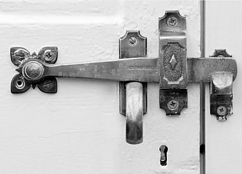 WEST_DEAN_GARDENS_WEST_SUSSEX_BLACK_AND_WHITE_IMAGE_OF_BRASS_DOOR_HANDLE_ON_THE_DOOR_OF_A_GLASSHOUSE