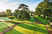 LAMPORT HALL, NORTHAMPTONSHIRE: VIEW OVER LAWN AND TREES FROM THE ROOF OF THE HALL IN MORNING LIGHT. FORMAL, HISTORIC, CLASSIC ENGLISH GARDEN