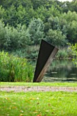 GREAT FOSTERS. SURREY:  THE JUGGERNAUT OF NAUGHT - SCULPTURE IN MILD WELDED STEEL BY RICHARD TRUPP BESIDE THE LAKE - ART, CONTEMPORARY