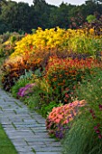 RHS GARDEN, WISLEY, SURREY: THE FAMOUS DOUBLE MIXED BORDER IN SEPTEMBER STRETCHING 128 METRES DOWN THE HILL - GRASS, PERENNIALS, SUMMER, GARDEN, CLASSIC