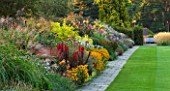 RHS GARDEN, WISLEY, SURREY: THE FAMOUS DOUBLE MIXED HERBACEOUS BORDER IN SEPTEMBER STRETCHING 128 METRES DOWN THE HILL - GRASS, PERENNIALS, SUMMER, GARDEN, CLASSIC