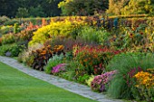 RHS GARDEN, WISLEY, SURREY: THE FAMOUS DOUBLE MIXED HERBACEOUS BORDER IN SEPTEMBER STRETCHING 128 METRES DOWN THE HILL - GRASS, PERENNIALS, SUMMER, GARDEN, CLASSIC