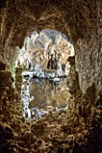 PAINSHILL PARK, SURREY: THE CRYSTAL GROTTO - VIEW THROUGH WINDOW OPENING TO LAKE AND REFLECTIONS - CLASSIC, OOLITIC LIMESTONE, STALACTITES, MYSTERY, LANDSCAPE GARDEN, ORNAMENT