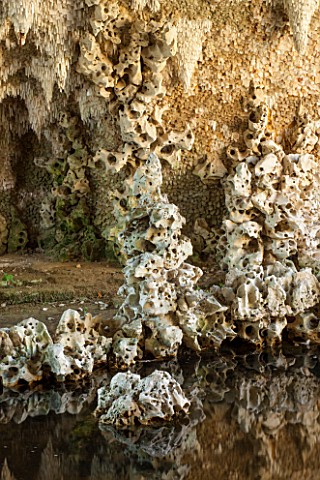 PAINSHILL_PARK_SURREY_THE_CRYSTAL_GROTTO__THE_GROTTO_WITH_REFLECTIONS_IN_WATER__CLASSIC_OOLITIC_LIME