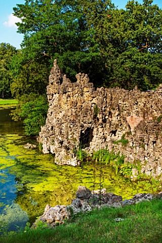 PAINSHILL_PARK_SURREY_THE_CRYSTAL_GROTTO_SEEN_FROM_OUTSIDE_WITH_THE_LAKE__CLASSIC_OOLITIC_LIMESTONE_