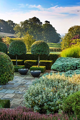 SURREY_GARDEN_DESIGNED_BY_ANTHONY_PAUL_VIEW_ACROSS_TERRACE_TO_COUNTRYSIDE_BEYOND_WITH_PONDS_IN_CONTA