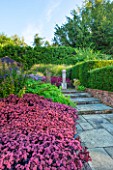 SURREY GARDEN DESIGNED BY ANTHONY PAUL: VIEW ALONG PATH TO FOCAL POINT OF POLISHED STONE SCULPTURE BY PAUL VANSTONE, SEDUM - SUMMER, SEPTEMBER, COUNTRY GARDEN