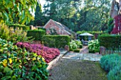 SURREY GARDEN DESIGNED BY ANTHONY PAUL: VIEW ALONG PATH WITH SEDUMS TO FORMAL GARDEN WITH BEDS PLANTED WITH HYDRANGEA ANNABELLE - SUMMER, SEPTEMBER, COUNTRY GARDEN