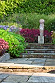 SURREY GARDEN DESIGNED BY ANTHONY PAUL: PATH WITH SEDUMS AND GRASSES TO FOCAL POINT OF POLISHED STONE SCULPTURE BY PAUL VANSTONE - SUMMER, SEPTEMBER, COUNTRY GARDEN