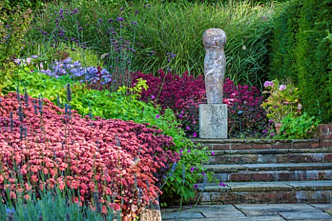 SURREY_GARDEN_DESIGNED_BY_ANTHONY_PAUL_SEDUMS_AND_GRASSES_AND_FOCAL_POINT_OF_POLISHED_STONE_SCULPTUR