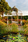 RYE HALL FARM, YORKSHIRE - DESIGNER SARAH MURCH - COUNTRY GARDEN - RUSTIC WHITE PAINTED METAL GAZEBO AND TABLE AND CHAIRS - A PLACE TO SIT, AUTUMN, OCTOBER, POND WITH WATERLILIES
